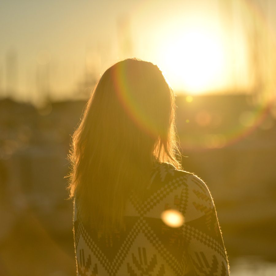 Woman Standing Against Facing Sun